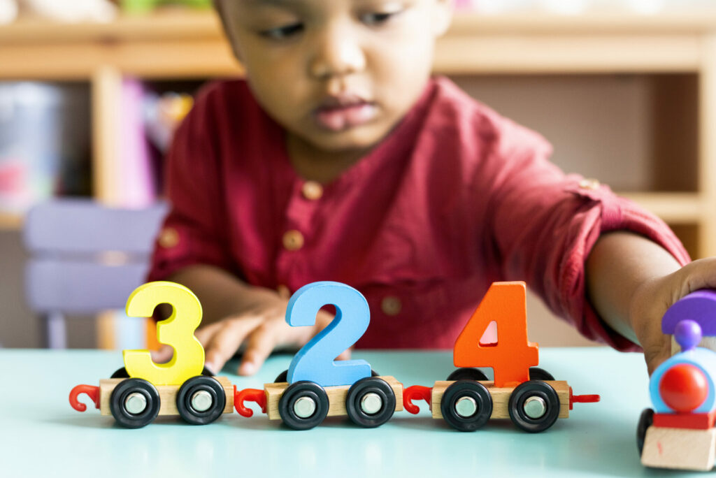 little boy playing with number train activity