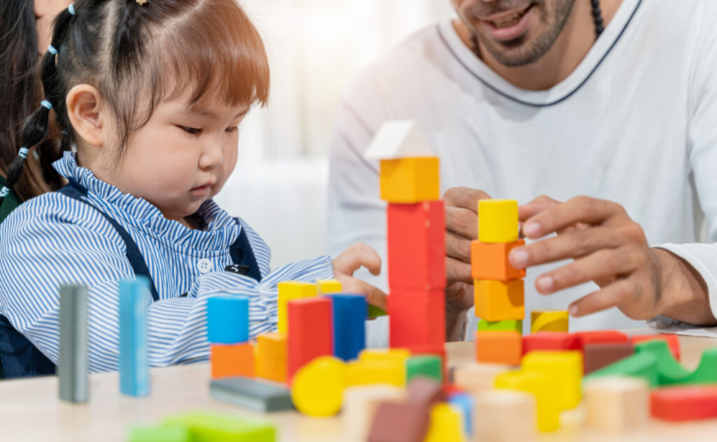 preschooler playing with blocks with parent